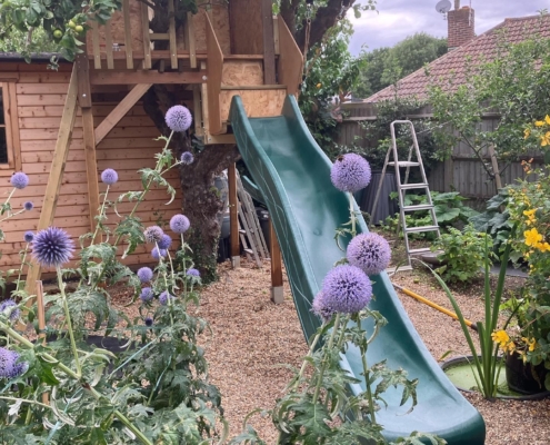 DIY playhouse, cleverly built in a large apple tree, complete with one of our 10ft wavy slides.